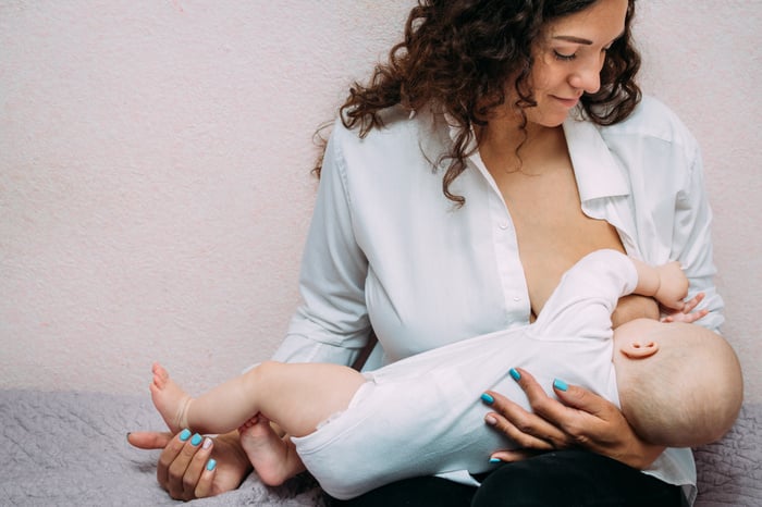 Mother Is Breastfeeding Her Baby on the Bed